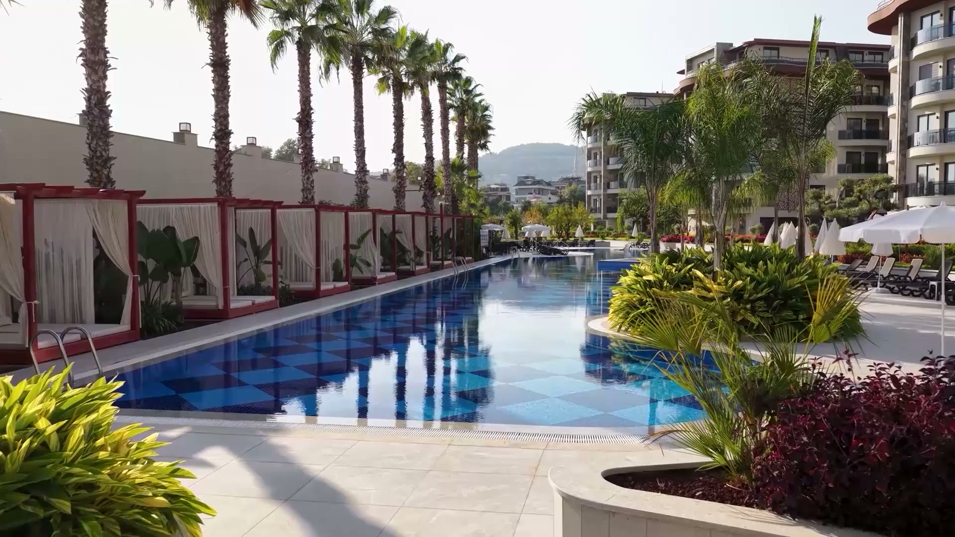 Basen w resorcie apartamentowym otoczony palmami